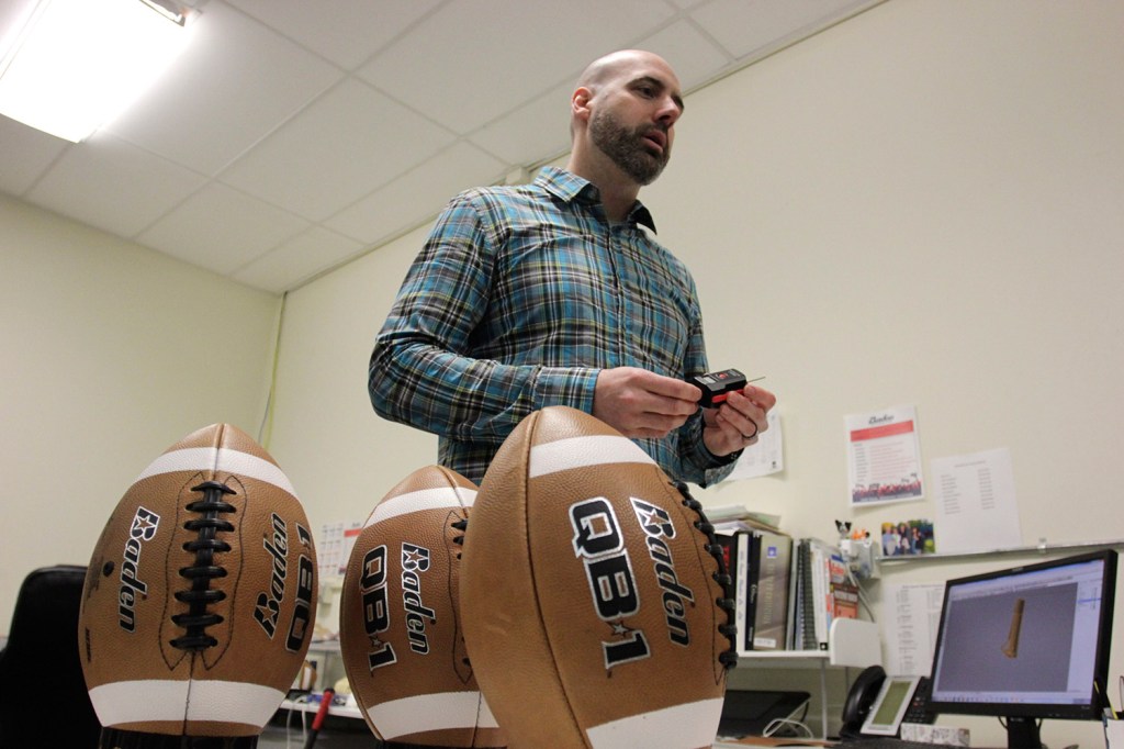 Baden Sports researcher director Hugh Tompkins shows footballs with different air pressures to be used in a demonstration, in Renton, Wash., on Thursday. Former Patriots quarterback Hugh Millen, who now helps design footballs for Baden, says quarterbacks prefer footballs with less air because of better grip and faster throws.  The Associated Press