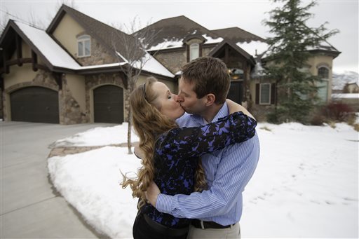 Jeff Bennion and his wife Tanya kiss in front of their home near Salt Lake City. Their relationship is featured in TLC's upcoming reality show "My Husband's Not Gay." The Associated Press