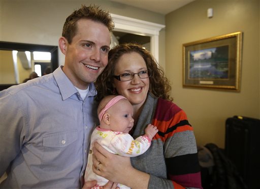 Preston "Pret" and Megan Dahlgren hold their daughter Naomi. Dahlgren says he's known he's attracted to men since he was about 12, but always wanted the kind of family he grew up in: a father, mother and children. The Associated Press