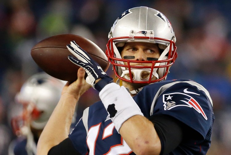 New England Patriots quarterback Tom Brady warms up before the NFL AFC Championship game Sunday night. On a Monday radio interview, Brady laughed off the accusation that the Patriots used underinflated footballs, calling it "ridiculous." The Associated Press