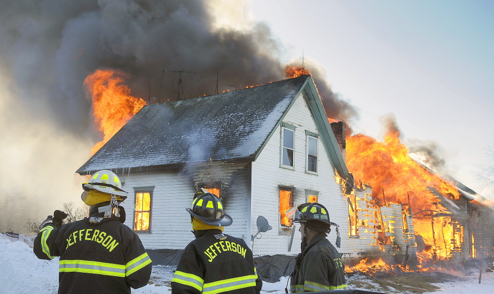 Jefferson firefighters assess a farmhouse that is fully engulfed in flames on Route 105 in Somerville on Sunday. Fire crews were able to rescue several animals at the farm before the fire overtook the barn.