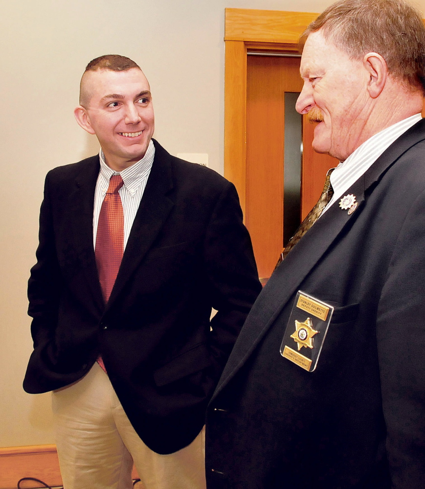 Michael Pike, left, the new domestic violence investigator for the Somerset County district attorney’s office in Skowhegan, chats with court officer Stanley Guilmette in the lobby of Skowhegan District Court on Monday.