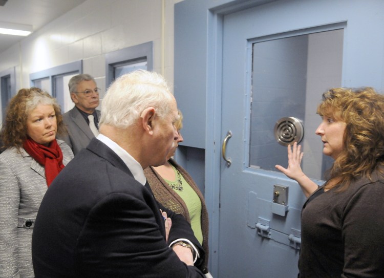 Kennebec County Corrections Capt. Marsha J. Alexander, right, shows members of the Legislature’s Criminal Justice and Public Safety Committee the exterior of a cell that holds high risk inmates during a tour of the jail in Augusta. Representatives and senators from across Maine got to see the overcrowded conditions at the Kennebec County Correctional Facility on Wednesday.