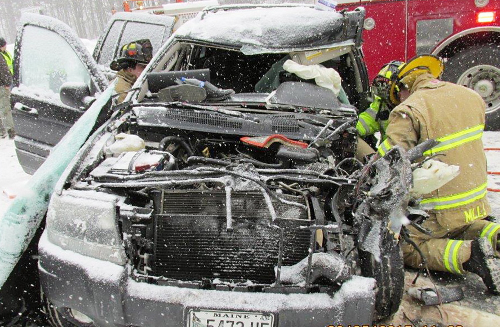 Augusta firefighters extricate victims from a sport utility vehicle that collided with a Department of Transportation snowplow Thursday on Interstate 95 in Augusta.