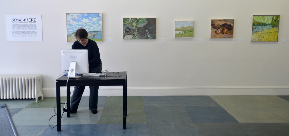 Lisa Wheeler, program manager at Common Street Gallery, prepares for an exhibit, “SomewHERE: Visions from Chinese and Taiwanese Artists in Maine,” opening at the Common Street Gallery in Waterville on Friday.