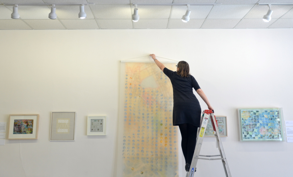 Ankeney Weitz, professor of art at Colby College, prepares for an exhibit, “SomewHERE: Visions from Chinese and Taiwanese Artists in Maine,” opening at the Common Street Gallery in Waterville on Friday.