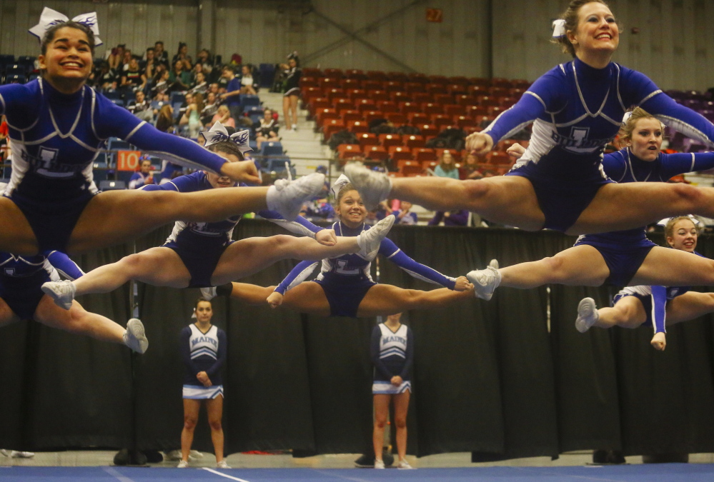 Maine Sunday Telegram photo by by Whitney Hayward 
 Lawrence cheerleaders jump into the air during their routine at the Class A state championships Saturday at the Augusta Civic Center.