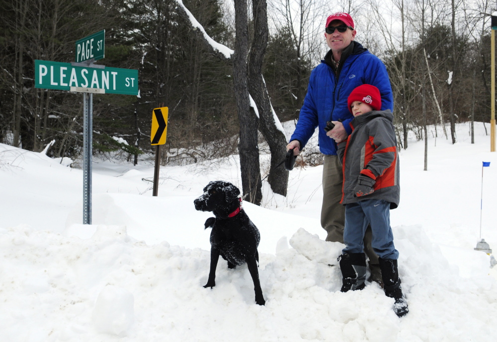 Jeremy Sheaffer stands at the corner of Pleasant and Page streets with his son Ben and dog Maisy on Wednesday at the edge of the Reed Center parcel in Hallowell.