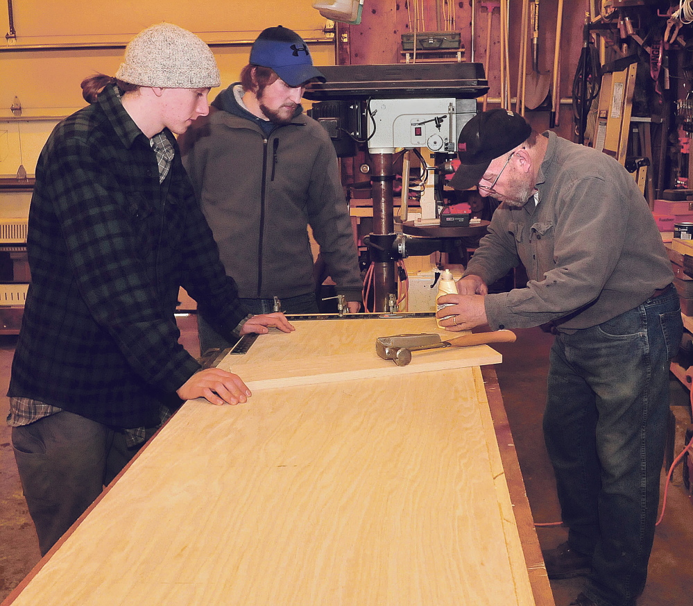 Carpenter Richard Tessier measures a countertop he and students Hannes Moll, left, and Issax Fletcher, of the Maine Academy of Natural Science made Tuesday in Skowhegan for radio station WXNX.