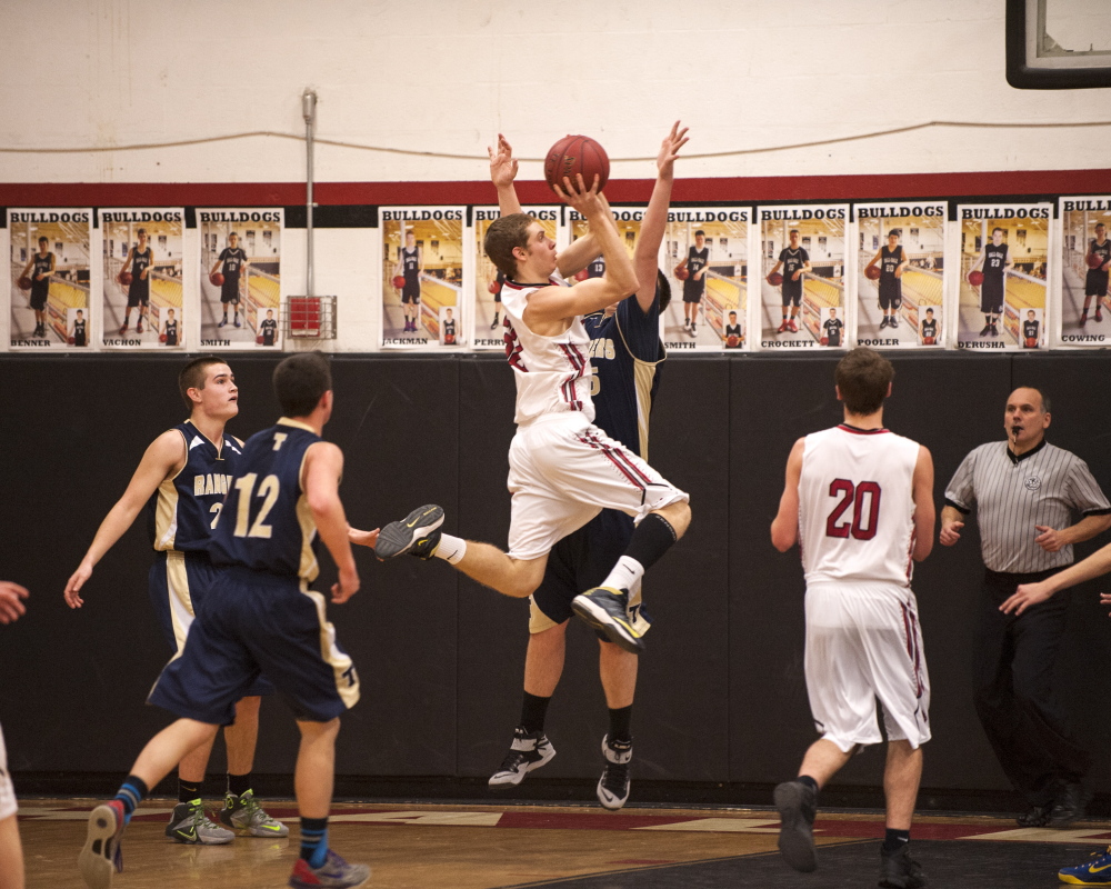 Hall-Dale’s Wes LaPointe goes up for a shot as Traip’s Angelo Succi (12) closes in to defend during a Western C prelim game Wednesday night.