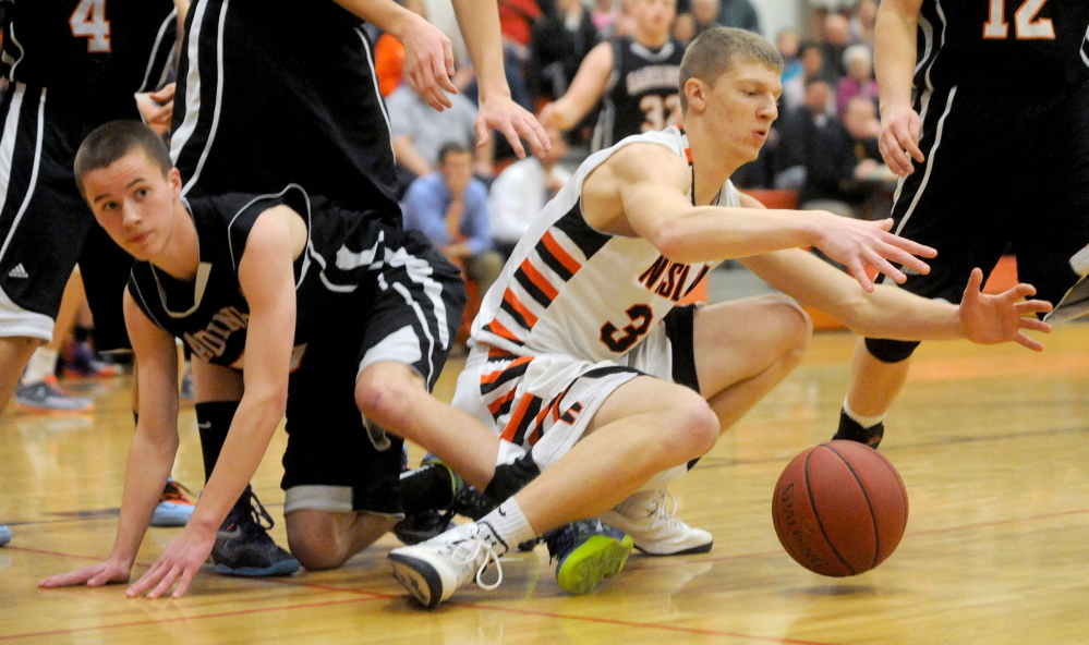 Staff photo by Michael G. Seamans 
 Winslow High School's Justin Martin, right, fights for a loose ball with Gardiner's Alex LaPointe in the first half of an eastern B game last month. The Tigers and Raiders are both in action Saturday at the Cross Insurance Center in Bangor for the Eastern B quarterfinals.