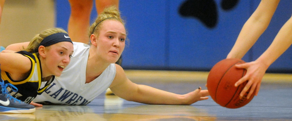 Mt. Blue High School’s Emilee Eustis, left, battles for the loose ball with Lawrence High School’s Nia Irving in the first half of an Eastern A game Jan. 31 in Fairfield. The Cougars and Bulldogs will play regional quarterfinal games Friday in Augusta.