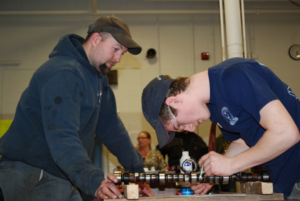 Tyler Pooler, right, a Winslow High School student, competes in one of the automotive competitions, while being judged by Craig Smiley.