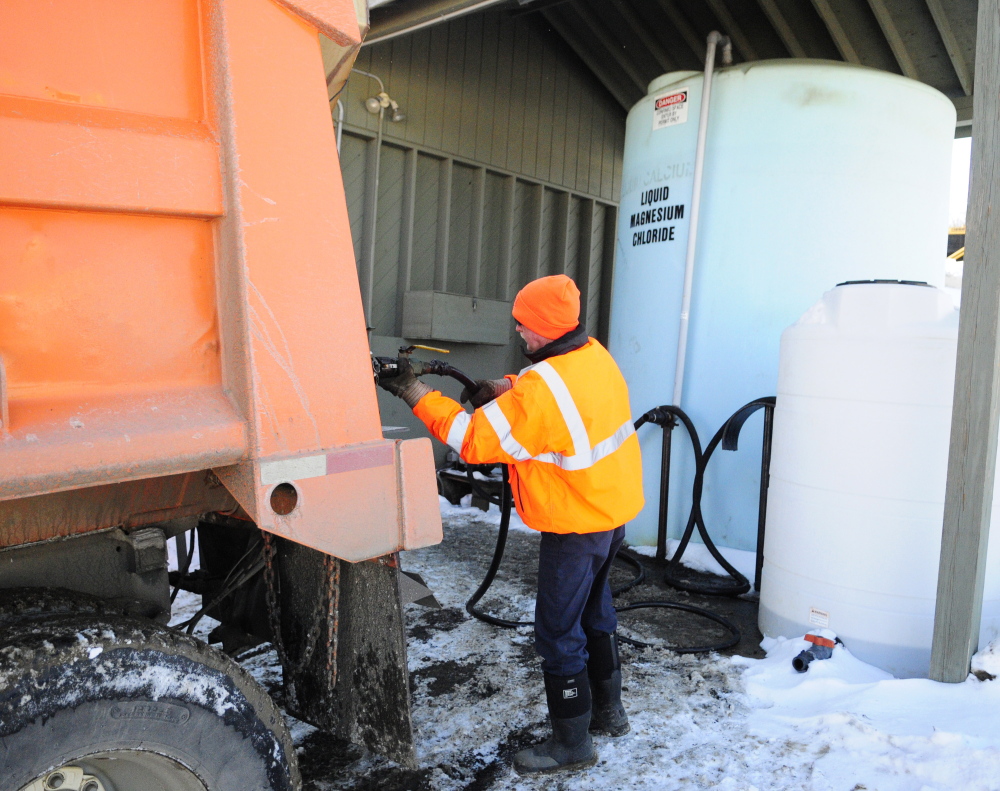 Brian McLaughlin pumps liquid magnesium chloride into a plow truck on Friday at the John Charest Public Works facility in Augusta. Public works staffers spent part of their Friday shifts preparing equipment for the storm forecast to hit the area this weekend.