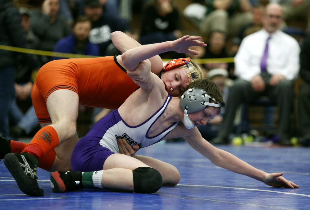 Cody Craig, of Skowhegan, above, competes with Kyle Glidden, of Marshwood, during the 106-pound division Class A State Championship. Craig went on to win the match and the title.