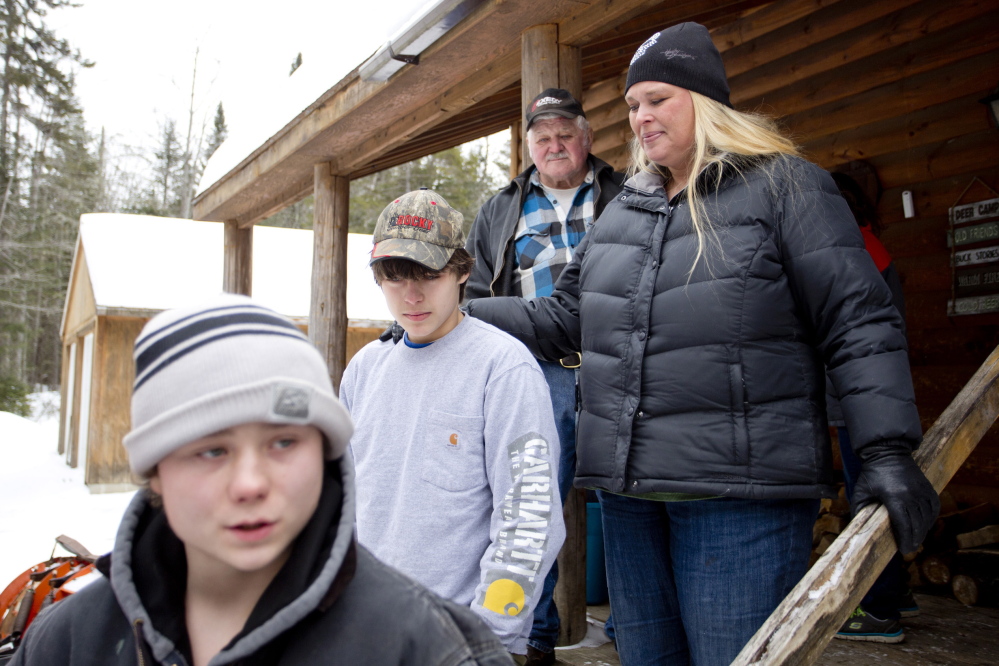 From left, Jonah May, 15, talks to the media as Tyler Howard-Gotto walks with his mother, Tracy Howard, after the two teens emerged from a night lost in the woods. Jonah said he counted on Tyler – and his survival knowledge – to get them out safely. “I trust this kid with my life,” he said.