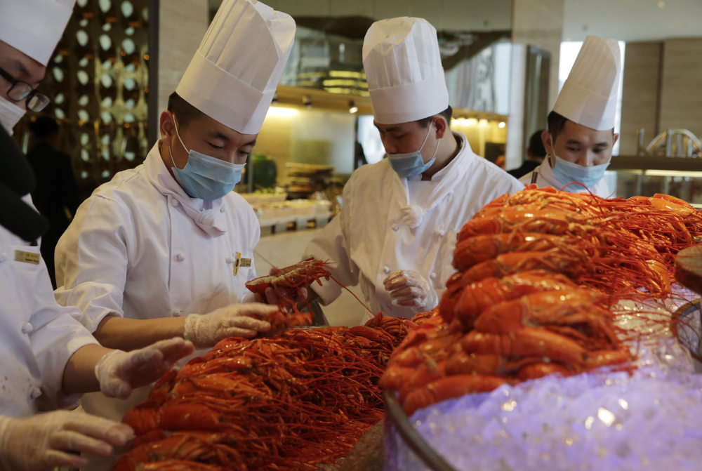 In this Feb. 9, 2015, photo, Chinese chefs prepare Boston lobsters at the Auspicious Garden restaurant in Pangu Seven Star Hotel in Beijing.