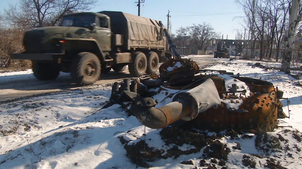 In this image made from TV, A truck drives past a destroyed tank as Russian backed rebel forces consolidate their position in Vuhlehirsk, Ukraine, Wednesday advancing on Debaltseve, about 4km (2 miles) from this position.