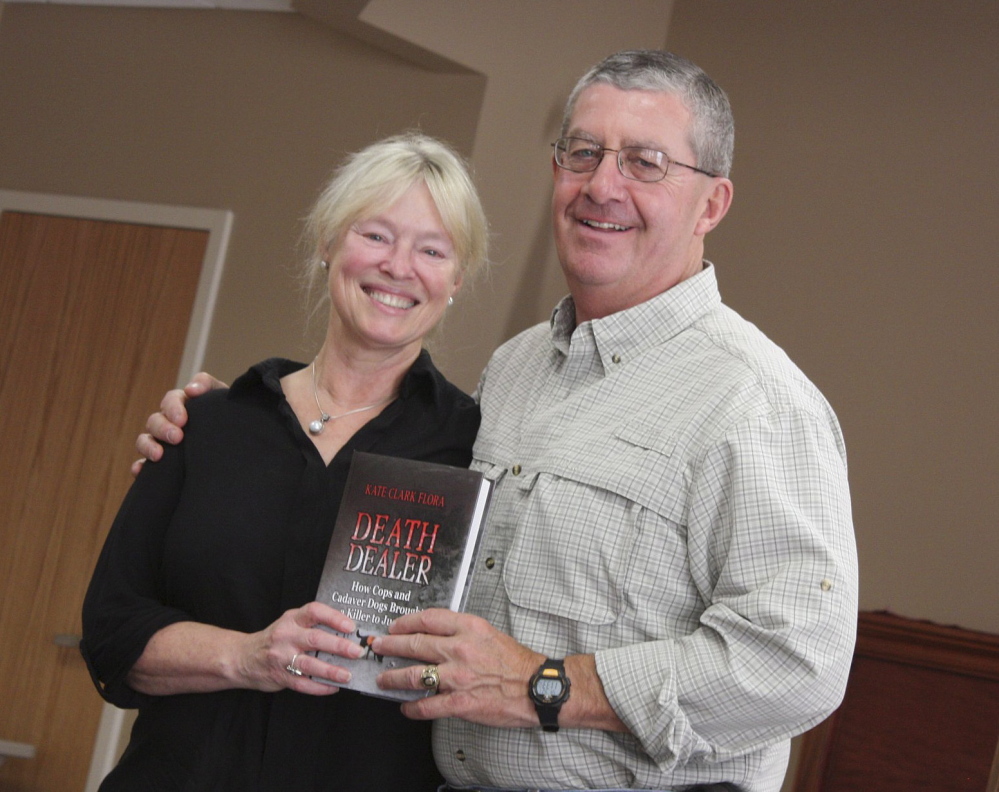 Kate Flora, left, and Pat Dorian, retired as a lieutenant from the Maine Warden Service, show off her latest book, “Death Dealer.” The book chronicles how volunteers from Maine Search and Rescue Dogs helped solve a New Brunswick murder.