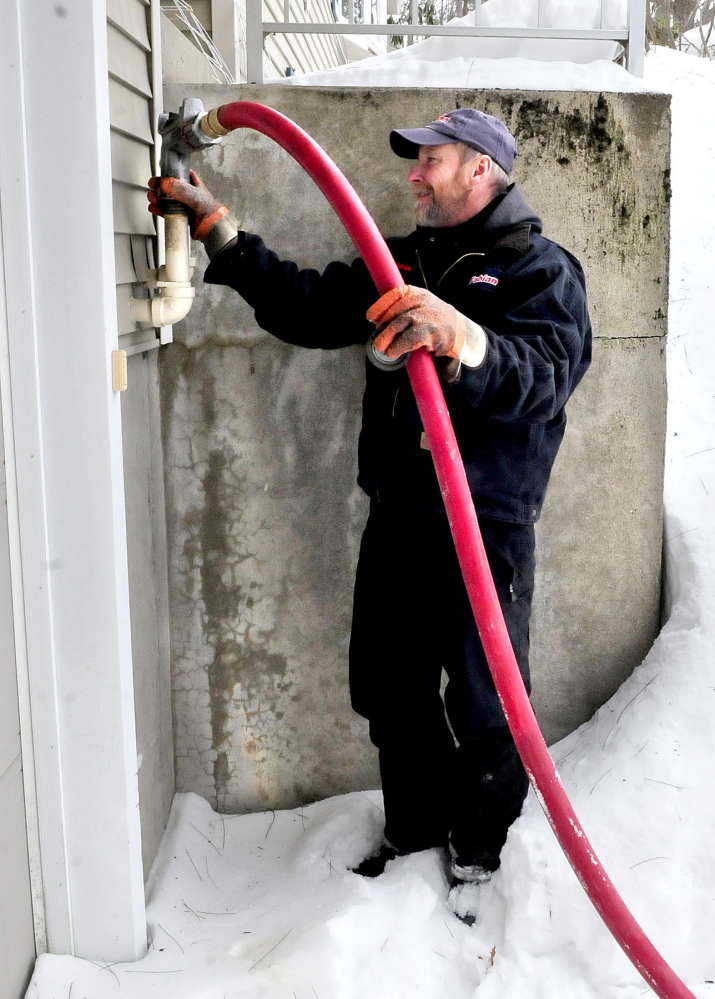 Kevin Keniston, of Fabion Oil, fills a tank with No. 2 heating oil Tuesday at a residence in Waterville.