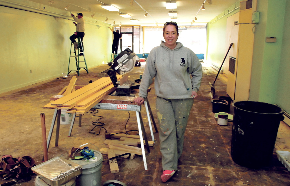 Loyal Biscuit Co. owner Heidi Neal takes a break from painting Wednesday with others at the business’s new location, the former Earth Bound store in downtown Waterville.