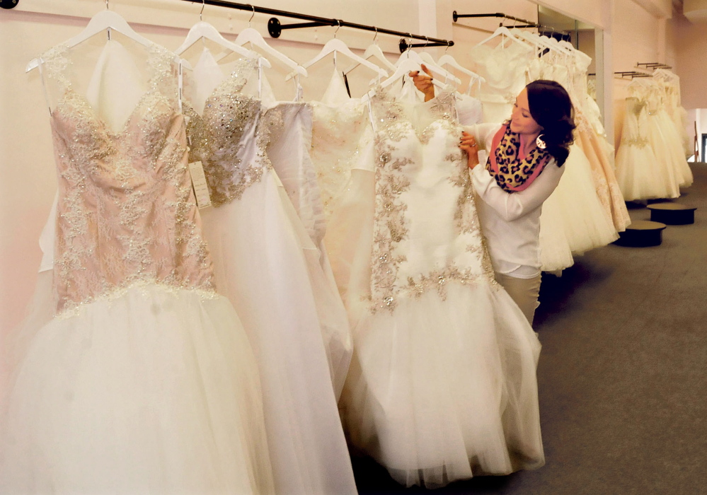 Linsey Gervais, owner of the La Belle Bridal Boutique, looks over her wedding dress inventory Wednesday at the store’s new location, 48 Main St. in Waterville.