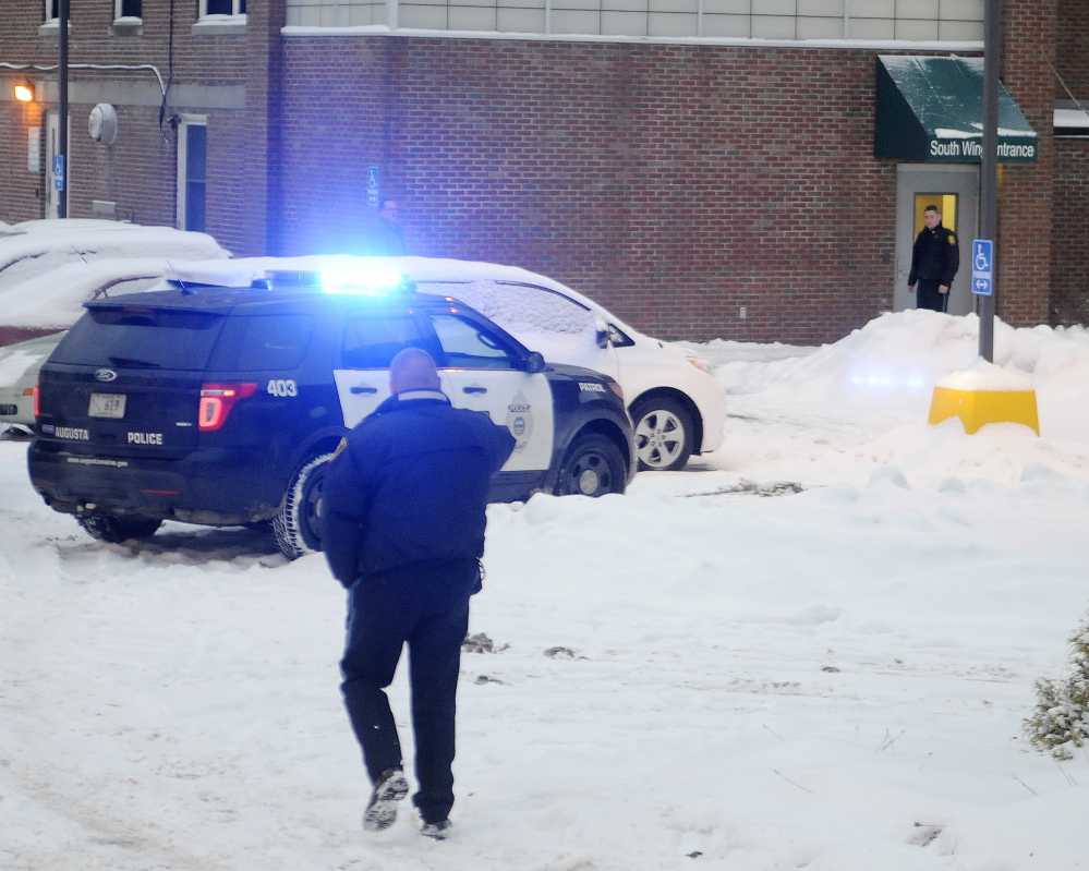 Police approach an entrance of the former MaineGeneral hospital on Chestnut Street in Augusta Jan. 12, a few minutes after a shooting in which an Augusta police officer shot a mentally ill man.