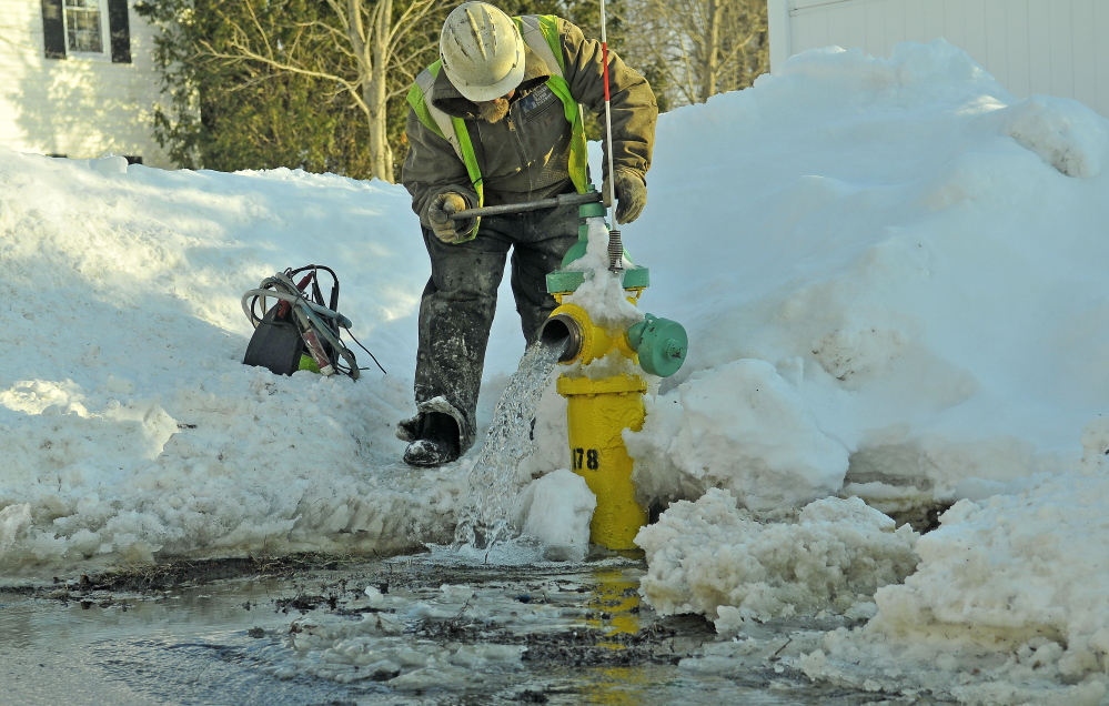 Darrell Field, a Kennebec Water District emmployee, bleeds the water lines as crews fix a water main break on Johnson Heights on Friday. District officials say the deep frost caused by the extreme cold this winter has been responsible for a number of broken water pipes in the area