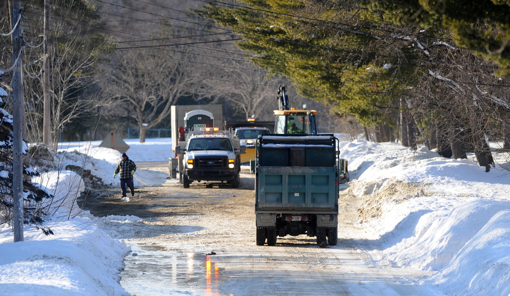 Crews from Kennebec Water District fix a water main break on Johnson Heights on Friday.