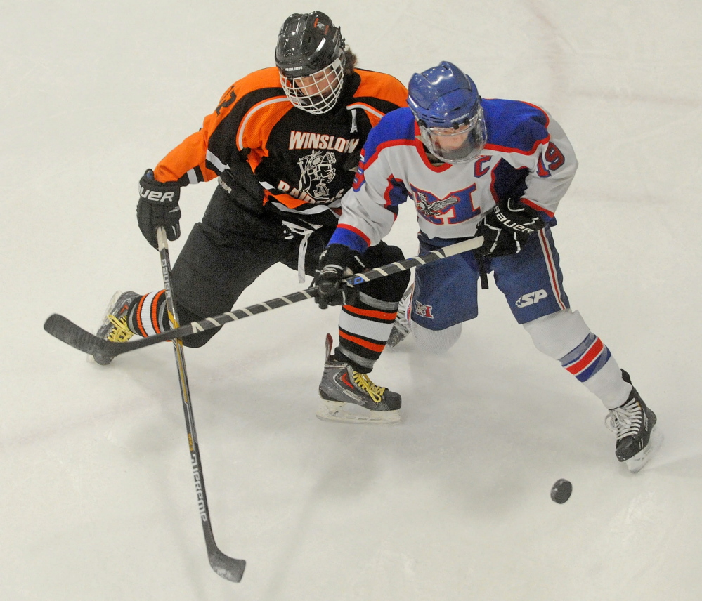 Messalonskee forward Jared Cunningham, right, battles for the puck with Winslow’s, Jake Larson during an Eastern B game Jan. 10 at Sukee Arena. The Eagles enter the Eastern B playoffs as the No. 1 seed.
