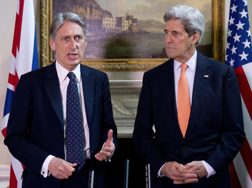 U.S. Secretary of State John Kerry looks on during a press conference with Britain’s Foreign Secretary Philip Hammond, left,  in central London on Saturday. Kerry, in London for talks with Hammond, said Russia’s conduct was “simply unacceptable” and that he expected to see agreement on further international sanctions in the coming days.