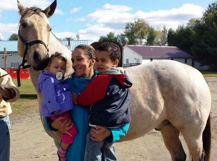 Nilsa Rodriguez, with her children, Jaylin, 1, and Joshua, 4, pose with a horse, Buckley, at the New Hope Women’s Shelter in Solon. Rodriguez and her children have been staying at the shelter for about four months and hope to move to an apartment of their own at the end of the month.