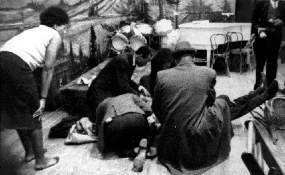 In this Feb. 21, 1965 file photo, Human rights activist Malcolm X is tended to as he lies mortally wounded on the stage of the Audubon ballroom in the Harlem section of New York after being shot multiple times.