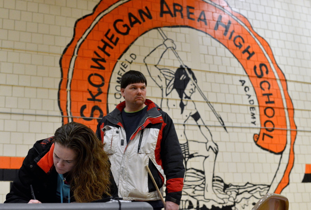 Ann-Marie Towle, 29, and her husband, Jeremy, both of Skowhegan, sign a petition to keep Skowhegan Area High School’s Indian mascot Saturday at the FAB Fair at Skowhegan Area High School.