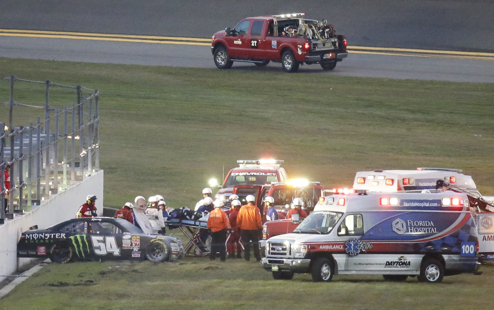 Kyle Busch, center, is taken to an ambulance on a stretcher after he was involved in a multi-car crash during the Xfinity series race at Daytona International Speedway on Saturday in Daytona Beach, Fla. Busch will miss Sunday’s Daytona 500 due to injuries sustained in the crash.