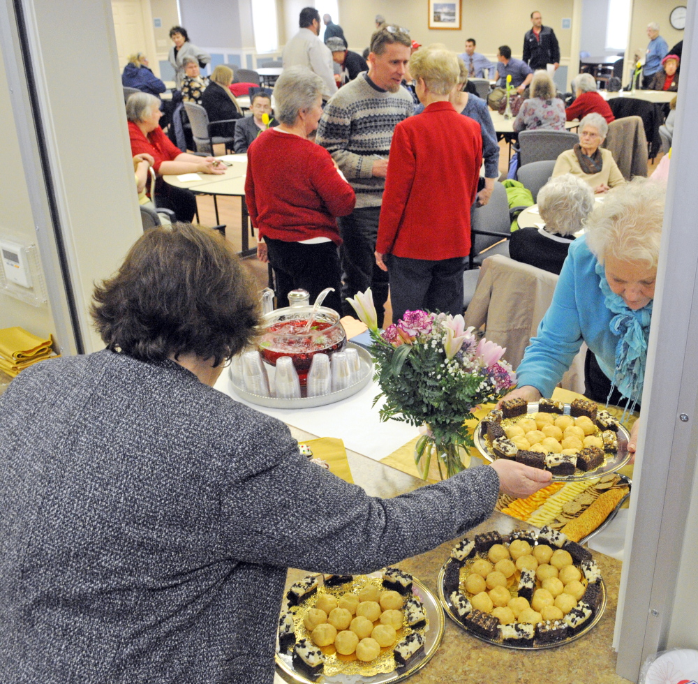 Board members Mary Moody, left, and Linda Gilson set up refreshments Tuesday after a dedication ceremony for a new community center at Arch Beta apartments in Augusta.