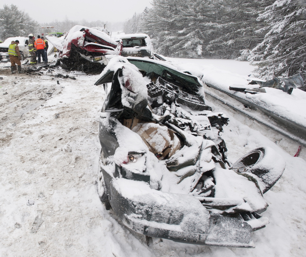 a;kljsfd;ljl;kj .... Carmel, Maine-02-25-2015-- Bangor Police detective Larry Morrill sips coffee as he walks among the wreckage of a mutiple car pileup on intersate 95 in Carmel. Morrill was involved in his personal vehicle. The car in the left of the frame was under the school bus when police arrived. The driver escaped with only scratches according to people who helped him out of the car.
Kevin Bennett Photo