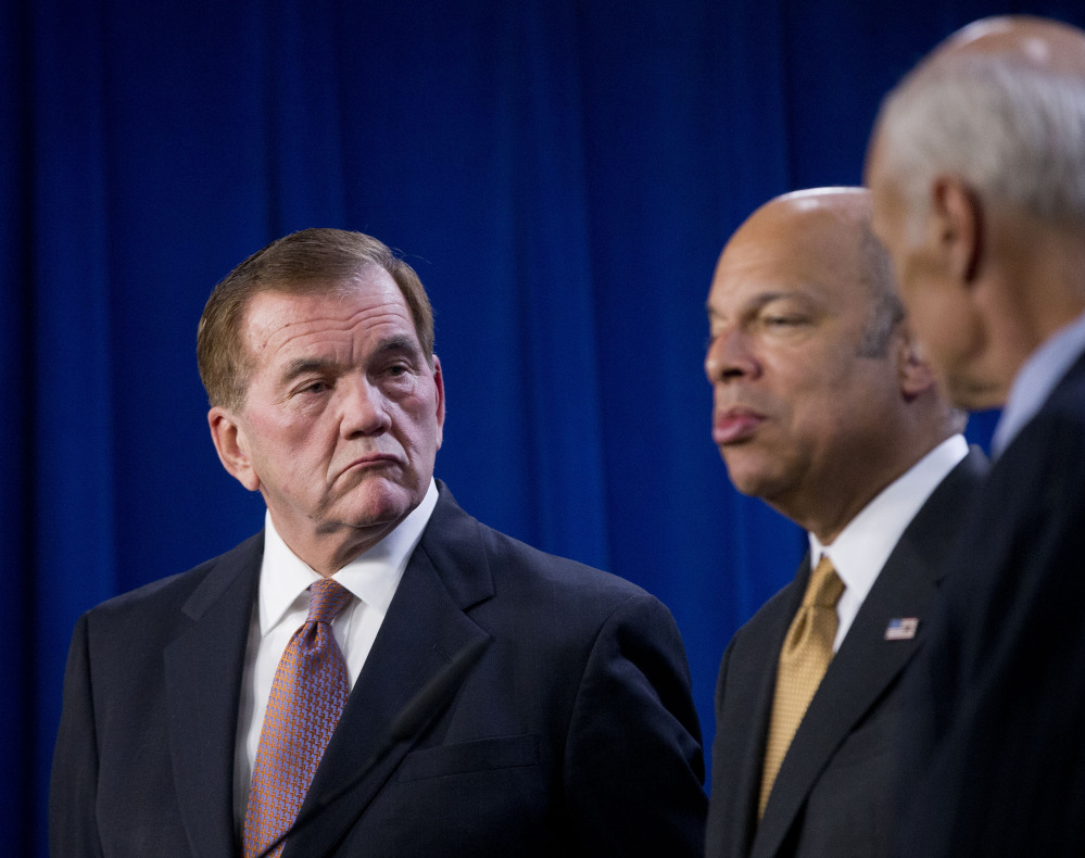 Former Homeland Security Secretary Tom Ridge listens at left as current Homeland Security Secretary Jeh Johnson speaks during a news conference in Washington on Wednesday. Johnson said that without legislation to set new spending levels, there would be no money for new initiatives.