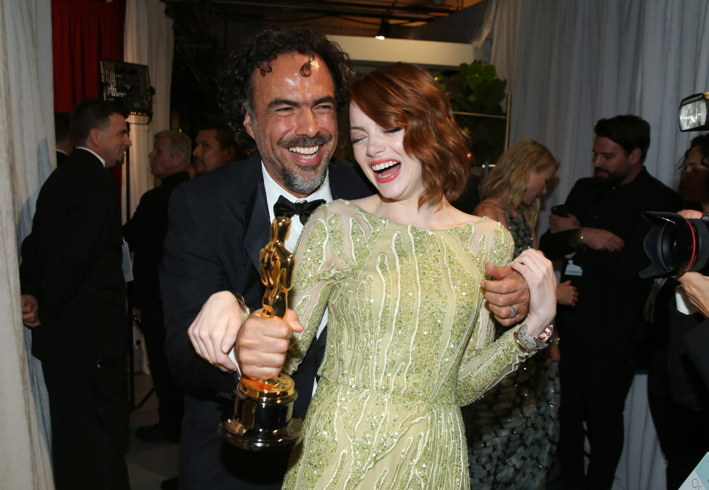 Alejandro Gonzalez Inarritu, left, and Emma Stone are seen backstage at the Oscars on Sunday at the Dolby Theatre in Los Angeles.