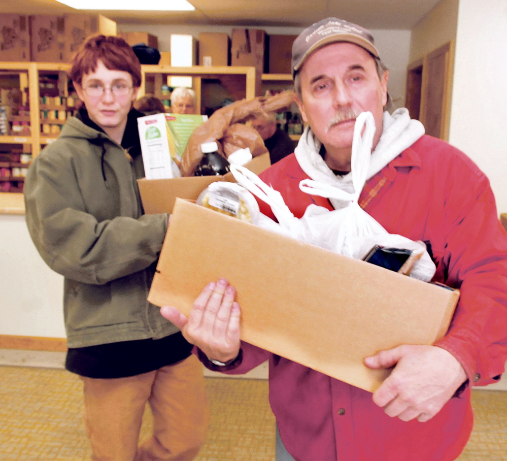 Volunteers Cameron Patterson, left, and Paul Cairnie carry out boxes of food for recipients on the first day at the new Fairfield Interfaith Food Pantry on Thursday.