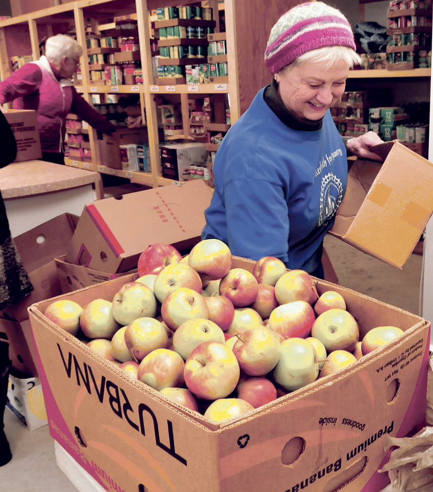 Volunteer Kathy Keup fills fruit requests at the new Fairfield Interfaith Food Pantry on Thursday.
