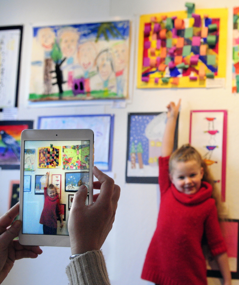 Mount Vernon Elementary School kindergartner Kyleigh Pinkham poses for a photo with her work Saturday at the opening of the Young at Art Show at the Harlow Gallery in Hallowell.