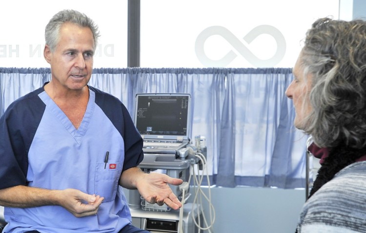 Dr. John Herzog of Falmouth, here with Yvette Bouttenot of Lewiston, tells patients about the benefits he has experienced from a vegan diet.