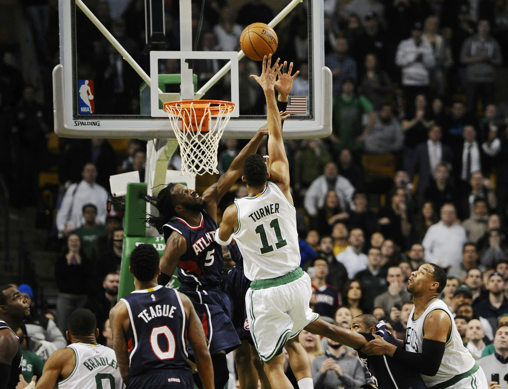 The Celtics’ Evan Turner shoots the game-winning basket over the Atlanta Hawks’ DeMarre Carroll (5) with 0.2 seconds left in Wednesday night’s game in Boston. The Celtics won, 89-88, on Turner’s buzzer-beater.