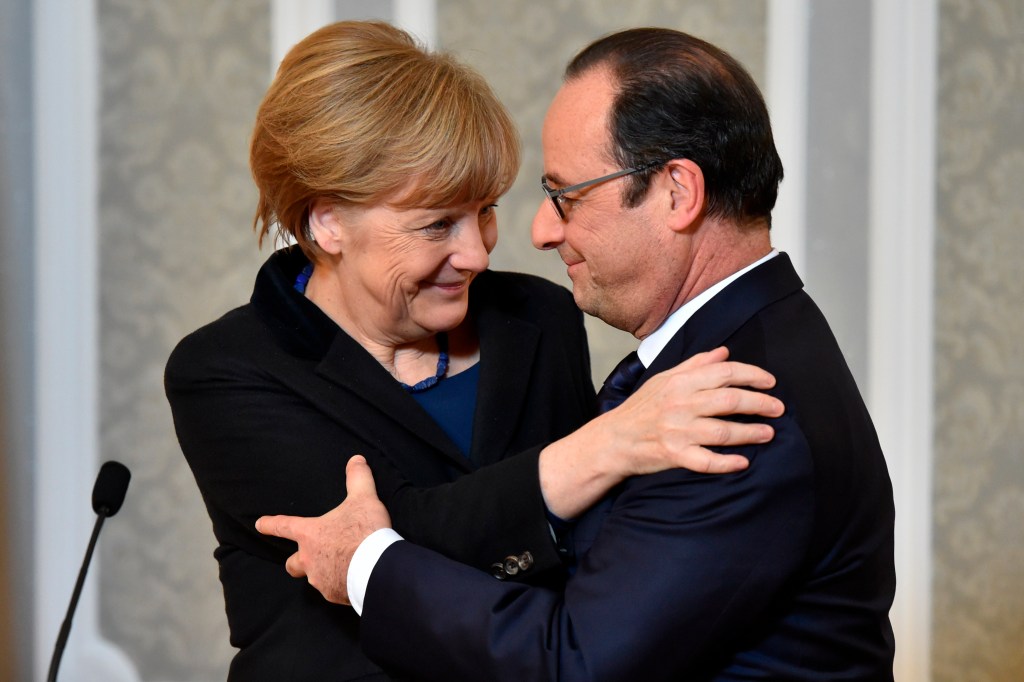 French President Francois Hollande,  and German Chancellor Angela Merkel hug after their marathon talks in Minsk, Belarus, Thursday. Hollande says he and German Chancellor Angela Merkel are committed to helping verify the cease-fire process in Ukraine, along with the Russian and Ukrainian leaders. He said  the  cease-fire deal has come as a "relief to Europe."  The Associated Press