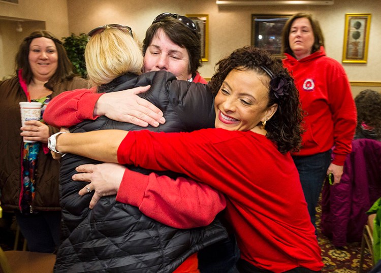 Fairpoint  employees hug during a meeting in Portland on Friday morning to vote on a prospective contract, ending four months of labor unrest.