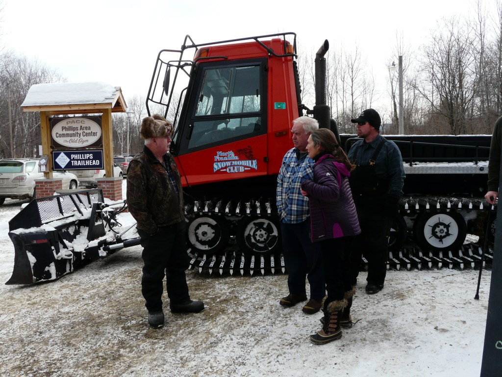 From left, the North Franklin Snowmobile Club’s groomer Dennis Presby, High Peaks Alliance volunteers Betsy Squibb and Douglas Marble, and George Berry gather on Saturday at the Phillips Area Community Center in Phillips to celebrate the Orbeton Stream Project conservation easement, completed in December.