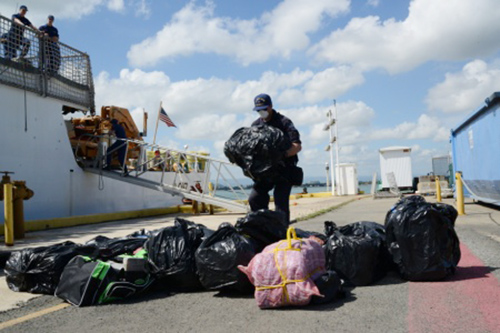 A Coast Guardsman helps offload approximately 1,100 pounds of cocaine in San Juan, Puerto Rico, on Tuesday. The contraband and three Dominican smugglers captured by the Coast Guard Cutter Tahoma were transferred to the Drug Enforcement Administration. U.S. Coast Guard photo