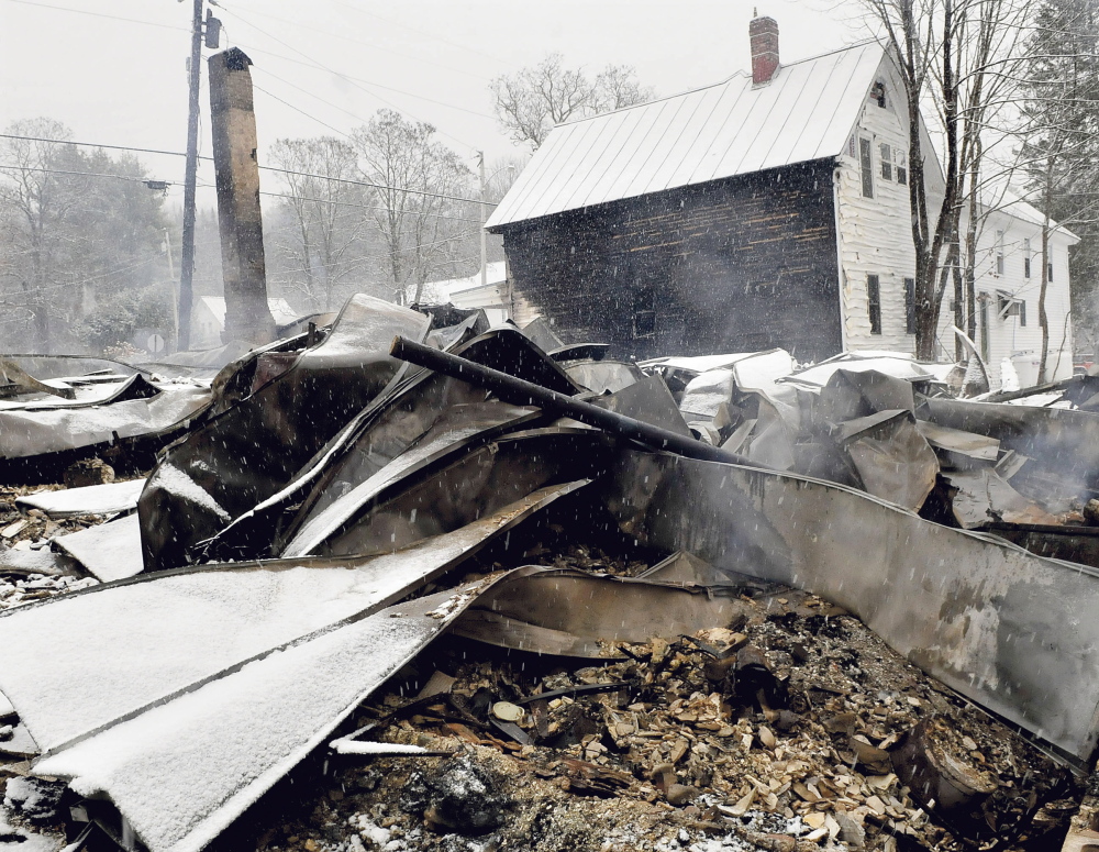 The home of Rick and Tina Belanger lies in blackened ruins in front of the Caratunk post office on Nov. 17, the day after a fire destroyed the home, another nearby home, garage and did serious damage to the post office.