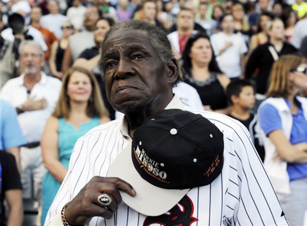 Former Negro Leaguer and Chicago White Sox player Minnie Minoso stands during the national anthem before a baseball game between the Chicago White Sox and the Texas Rangers in Chicago in April 2013.